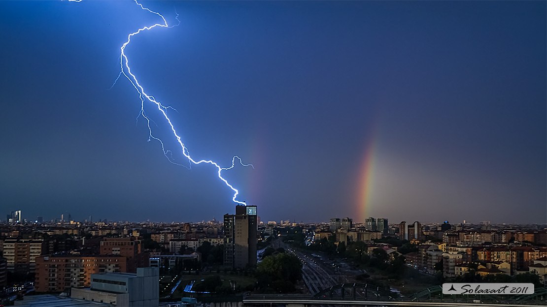 Temporale a Milano - tra due arcobaleni, un fulmine si scarica in mezzo alla città e sembra colpire un grattacielo -